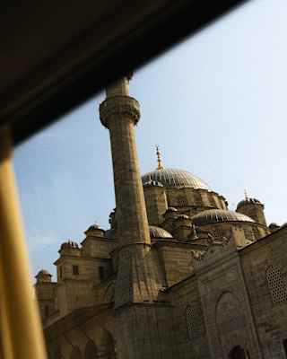 Looking up at the minarets, dome and beautiful Ottoman architecture of Istanbul's New Mosque, seen through the train window.