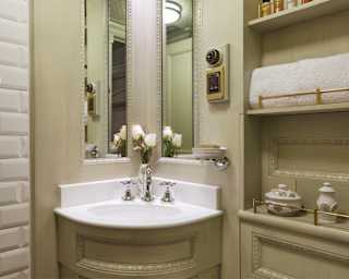 Train cabin bathroom with white tiles, light sage walls and curved corner sink