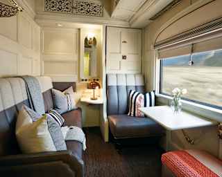 Light and airy train cabin with a leather banquette sofa and chair with table