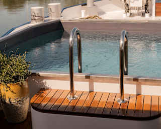 View over the plunge pool at the prow of the Lilas as it noses its way towards a bridge spanning a serene Burgundy canal.