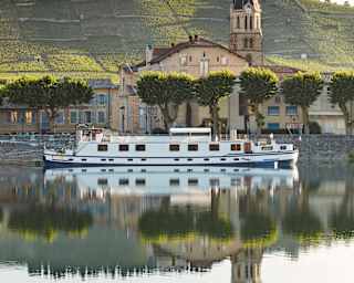 The Napolean cruises the calm River Rhône, which reflects Tain-L'Hermitage and its famous Côtes du Rhône vineyards beyond.