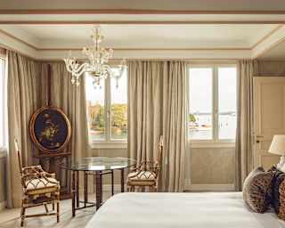A charming bedroom furnished in creams and golds enjoys views over the wooded southern tip of San Giorgio Maggiore island