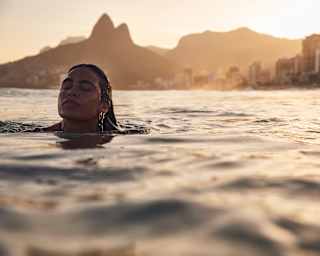 Close-up of a woman peacefully swimming in the sea at sunset