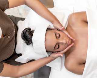 Birds-eye-view of a lady on a massage table enjoying a facial spa treatment
