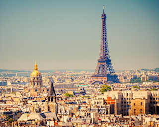 The Eiffel Tower rising above Paris skyline into clear blue skies