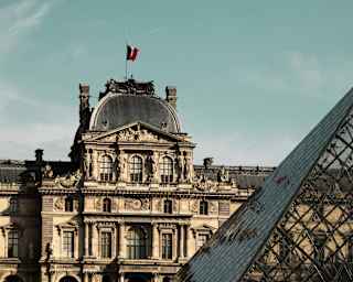 View of the Pavillon Richelieu wing of the Louvre Museum in Paris, France, part-obscured by the glass pyramid entrance.