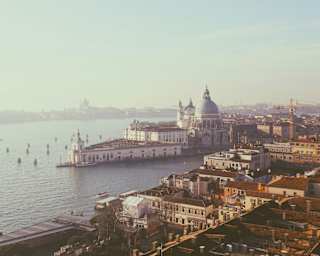 Aerial view above San Marco, looking over the Grand Canal and Punta della Dogana to Giudecca, bathed in a haze of morning sun.