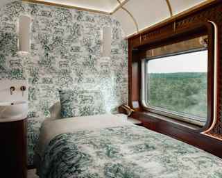 A window spills light on to a Dior Spa treatment bed with Toile De Jouy covers, complementing a feature wall behind.