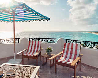 Two red-striped deck-chairs and parasol with on a panoramic private terrace