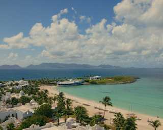 High view over Cap Juluca's Greco-Moorish buildings to the tropical blend of white sand and turquoise waters of Maundays Bay.