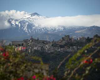 The incredible rise and snowy peak of Mount Etna looms south of Taormina's hills, seen through the lens of Gregory Halpern.