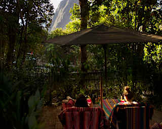 Two guests sat in the gardens facing the Machu Picchu mountains