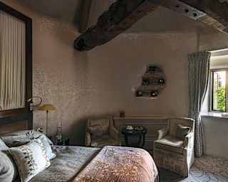 Rich textures touch every surface from the patterned carpet to velvet armchairs, floral throw to gnarled wooden beams