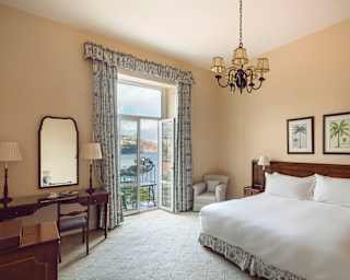 Natural light and ocean scenes fill the Deluxe Sea View Room, which has a large double bed and is decorated in soft neutrals.