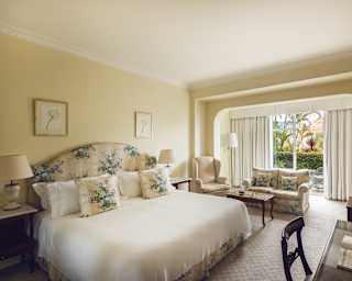 An archway divides the living area from the bedroom in a suite with flowing décor of silk tones and wildflower fabrics.