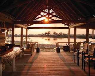 Sunset at the Fish Eagle Bar at Eagle Island Lodge overlooking the river from an open wooden terrace