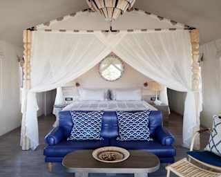 King-size four poster bed in safari tents are protected by hanging mosquito nets