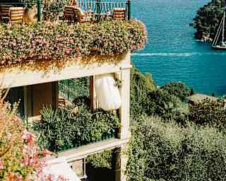 A stack of private terraces, dripping with trailing, flowering plants, soak in the views of the incredible Portofino coast.