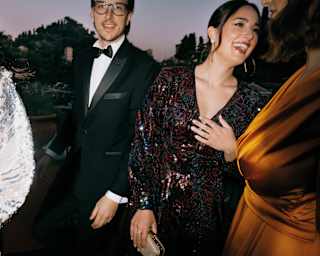 Four elegantly dressed guests laughing and celebrating