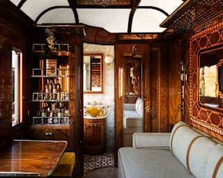 The Istanbul Suite living area, with bottle shelves and white banquette, encased in polished wood with exquisite marquetry.