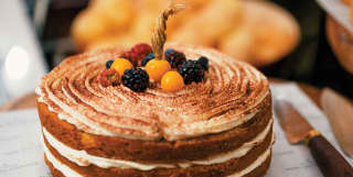 Handmade three-layer sponge cake decorated with fresh fruit and berries