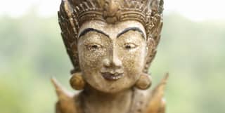 Close-up of a smiling traditional Balinese stone figurine