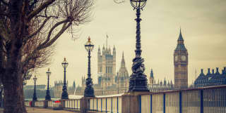 Big Ben viewed from a London embankment lined with ironwork street lamps