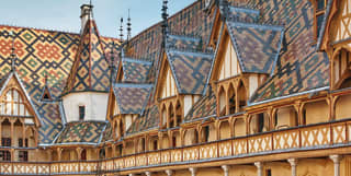 The distinctly patterned blue, green and red glazed roof tiles of the Beaune hospital