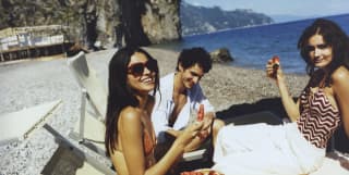 people on a beach in amalfi coast eating watermelon