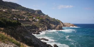Looking from Mirador Banyabulfar headland across the Bay of Banyabulfar, Mallorca, glimpsing its natural rock amphitheatre.