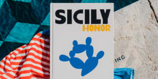 A copy of Sicily Honour, a study of the island's culture, history and myths by Gianna Riotta, rests on a poolside towel.