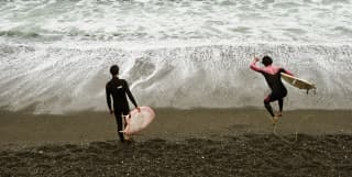 Surfers in wet suits enjoy the dramatic Pacific waves of Lima’s Costa Verdes beach