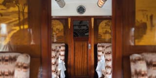 Train carriage with French-polished wall panels and a woodland marquetry design