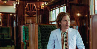 wes anderson seated on the british pullman train