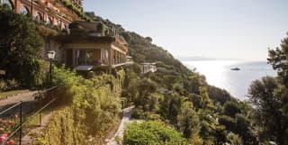 Classical Italian villa perched on a hilltop surrounded by lush Mediterranean gardens