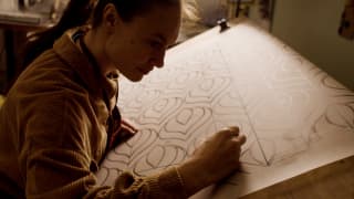 Eloise Baro, a graduate from the Mosaic School of Friuli in Spilimbergo, Italy, sketches out a pattern on a drawing board.