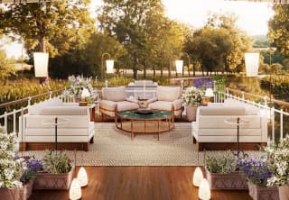 The opulent deck of the Coquelicot barge, with luxurious seating and soft furnishings, antique lighting and potted herbs.