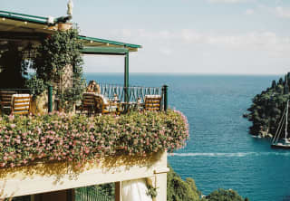 A stack of private terraces, dripping with trailing, flowering plants, soak in the views of the incredible Portofino coast.