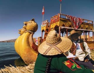 A woman from behind and a man wearing traditional from the Uros outfits