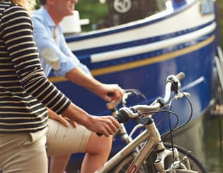 Close-up of a lady in a black and white striped top perched on a bike seat