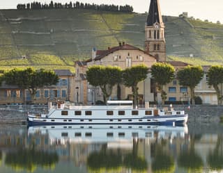 The Napolean cruises the calm River Rhône, which reflects Tain-L'Hermitage and its famous Côtes du Rhône vineyards beyond.