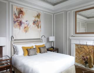 An original painting by Beatriz Elorza fills the wall from headboard to coving with muted pink, cream and lilac lilies