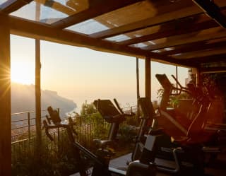 An outdoor gym enjoys views to die for, shaded from the sun by the terrace roof as the valley falls away below