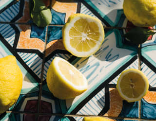 Birds-eye-view of chopped lemons on brightly-coloured tiles