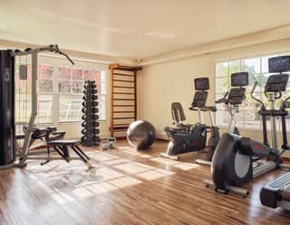 Gym studio with various gym equipment and polished hardwood floor