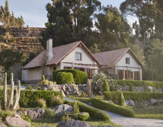 Two stone-built casitas side-by-side, surrounded by lush gardens