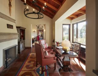 Lounge seating area with polished terracotta tiles next to a large fireplace