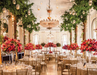 The great hall of the Crystal Room is filled with candle lit lanterns and stunning floral displays for a wedding banquet