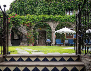 Old stone arches and pillars, covered with lush flowering climbers help create a historic garden area at Casa Limon