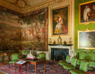A silk tapestry dominates the Green Drawing Room at Blenheim Palace, which houses portraits and emerald upholstery and walls.